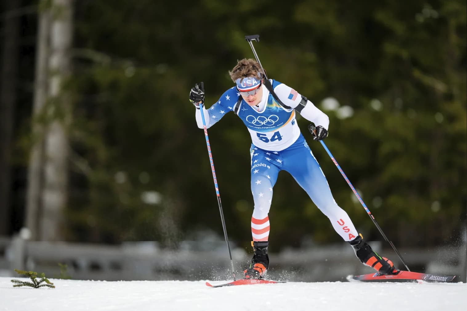 Campbell Wright of the United States skiing in the biathlon sprint, rifle on his back, at the Antholz Olympic venue.